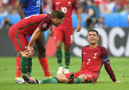 PARIS, FRANCE - JULY 10: Cristiano Ronaldo of Portugal lies injured as teammate Adrien Silva of Portugal (L) checks on him during the UEFA EURO 2016 Final match between Portugal and France at Stade de France on July 10, 2016 in Paris, France. (Photo by Laurence Griffiths/Getty Images)