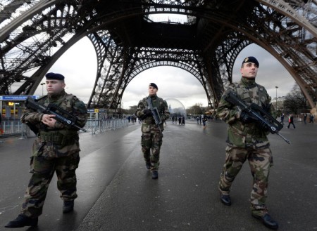 French soldiers patrol in front of the Eiffel Tower on January 8, 2015 in Paris as the capital was placed under the highest alert status a day after heavily armed gunmen shouting Islamist slogans stormed French satirical newspaper Charlie Hebdo and shot dead at least 12 people in the deadliest attack in France in four decades. A huge manhunt for two brothers suspected of massacring 12 people in an Islamist attack at a satirical French weekly zeroed in on a northern town Thursday after the discovery of one of the getaway cars. As thousands of police tightened their net, the country marked a rare national day of mourning for Wednesday's bloodbath at Charlie Hebdo magazine in Paris, the worst terrorist attack in France for half a century. AFP PHOTO / BERTRAND GUAY